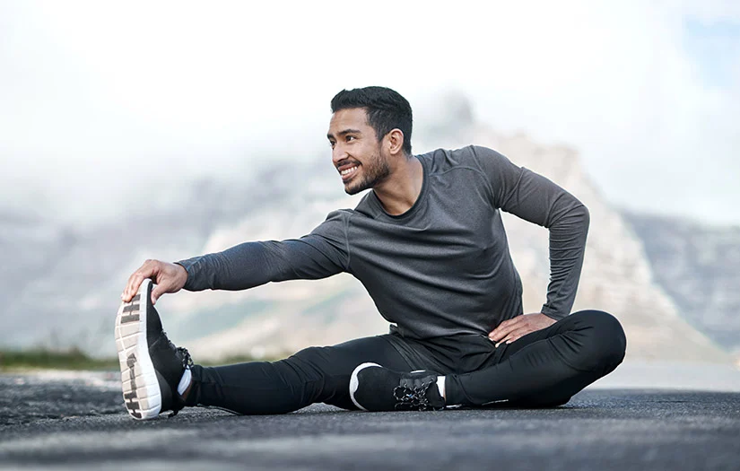 Image of a man stretching his leg happily.